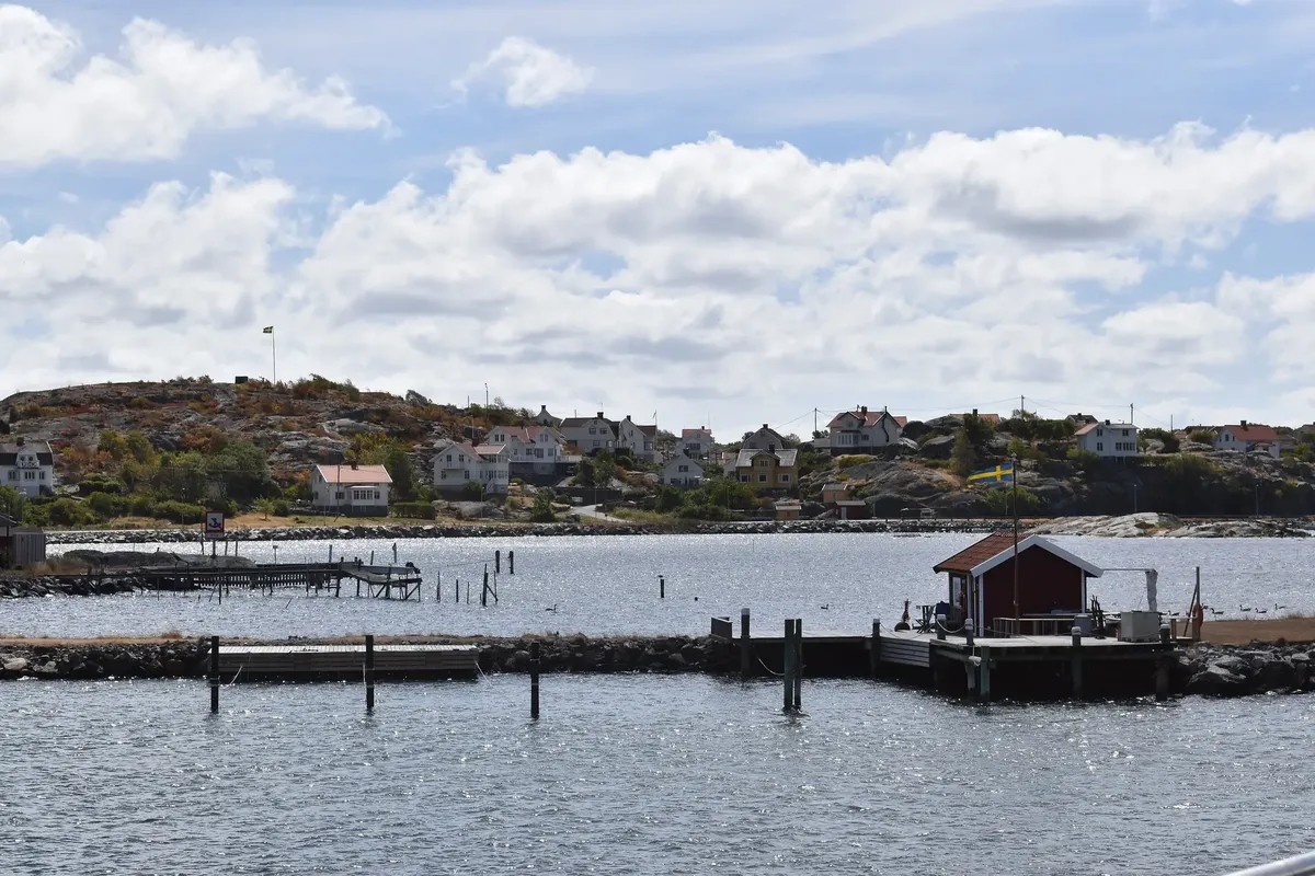 Donsö en sommardag, med bryggor, en röd sjöbod och hus på berget